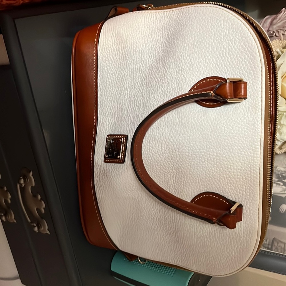 Dooney &Bourke white with brown trim. Used Good Condition. Has shoulder strap